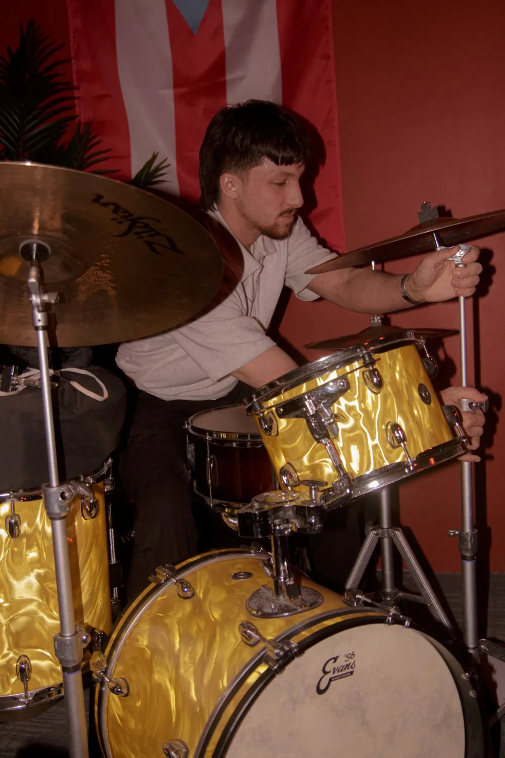 Paris Catura playing a gold-sparkle drum kit before a show